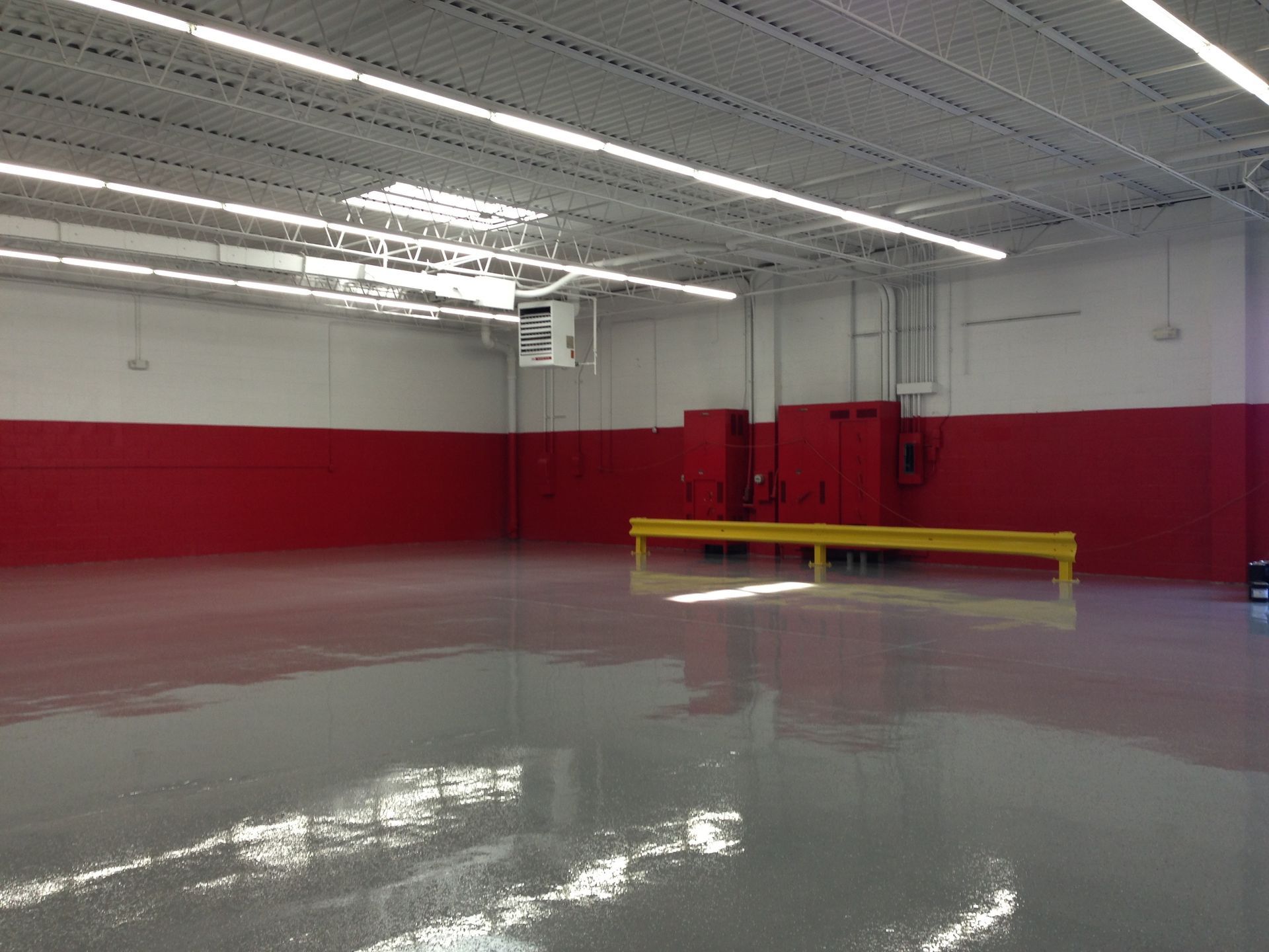 a large empty room with red walls and a gray floor