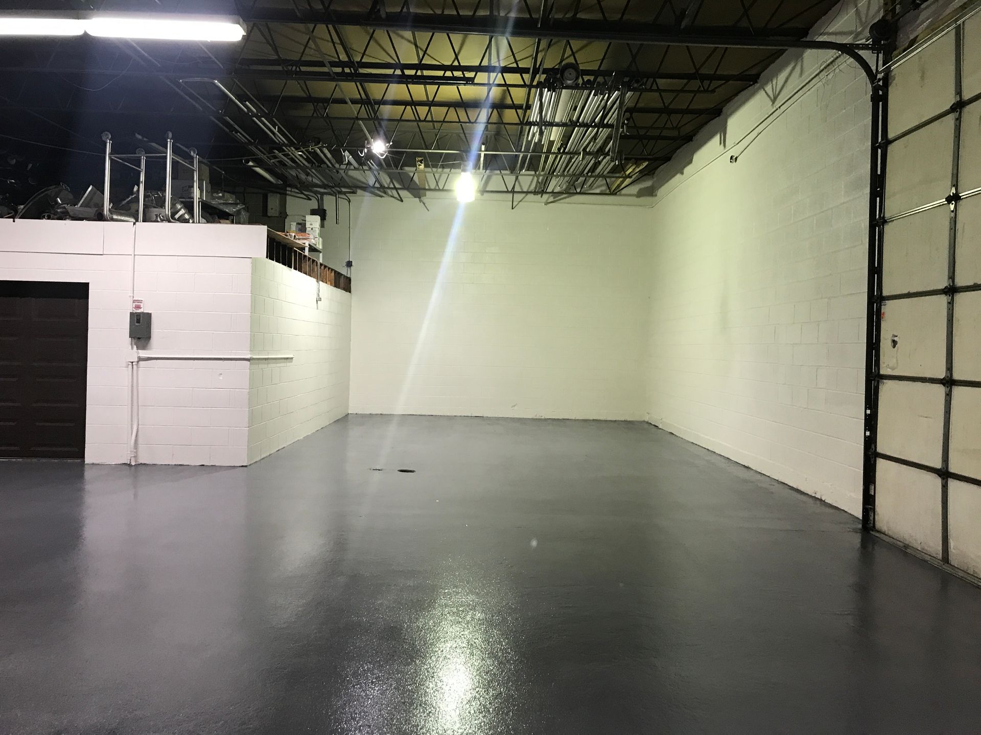 a large empty warehouse with a gray floor and white walls
