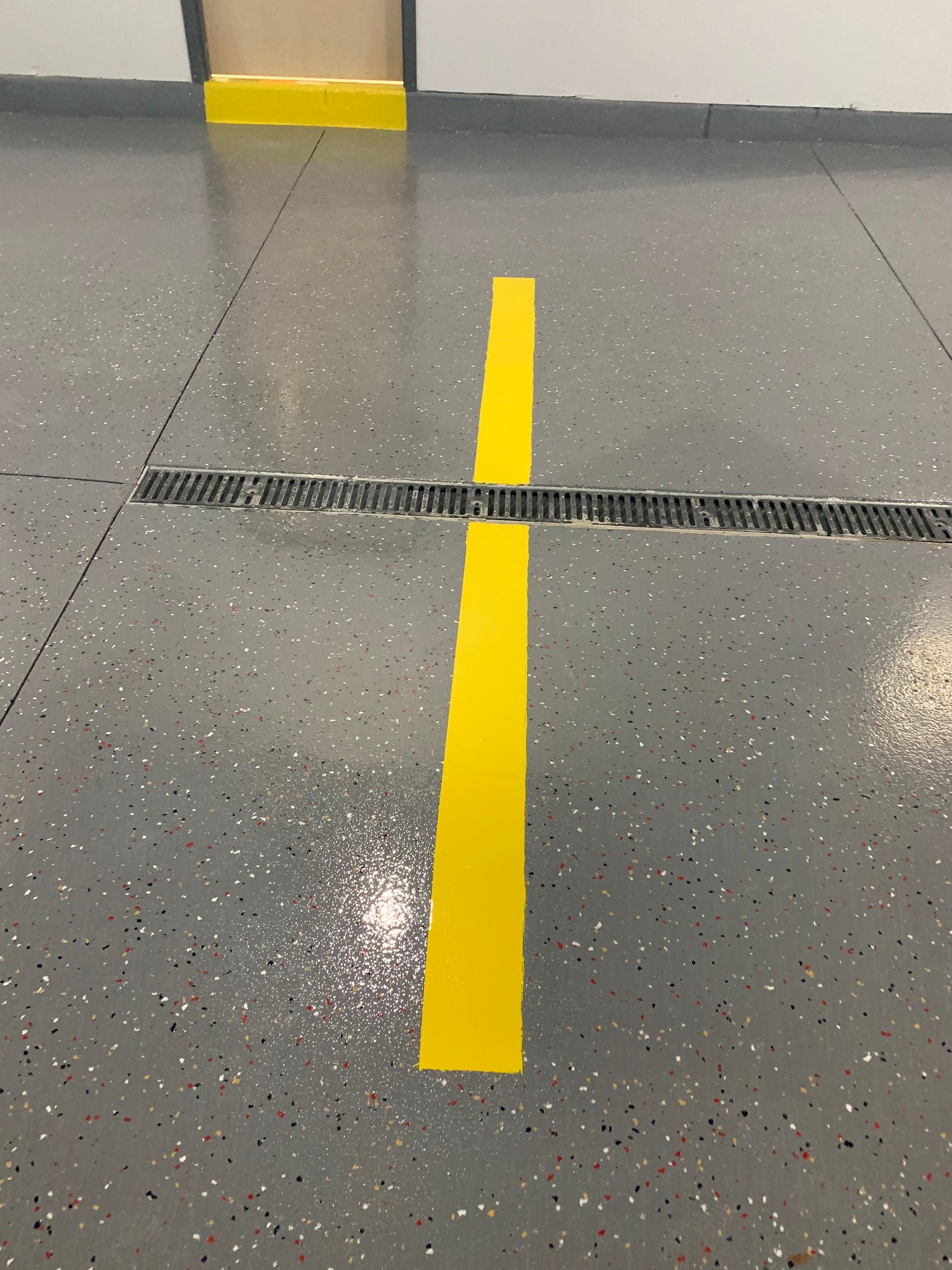 a yellow line is painted on the floor of a garage