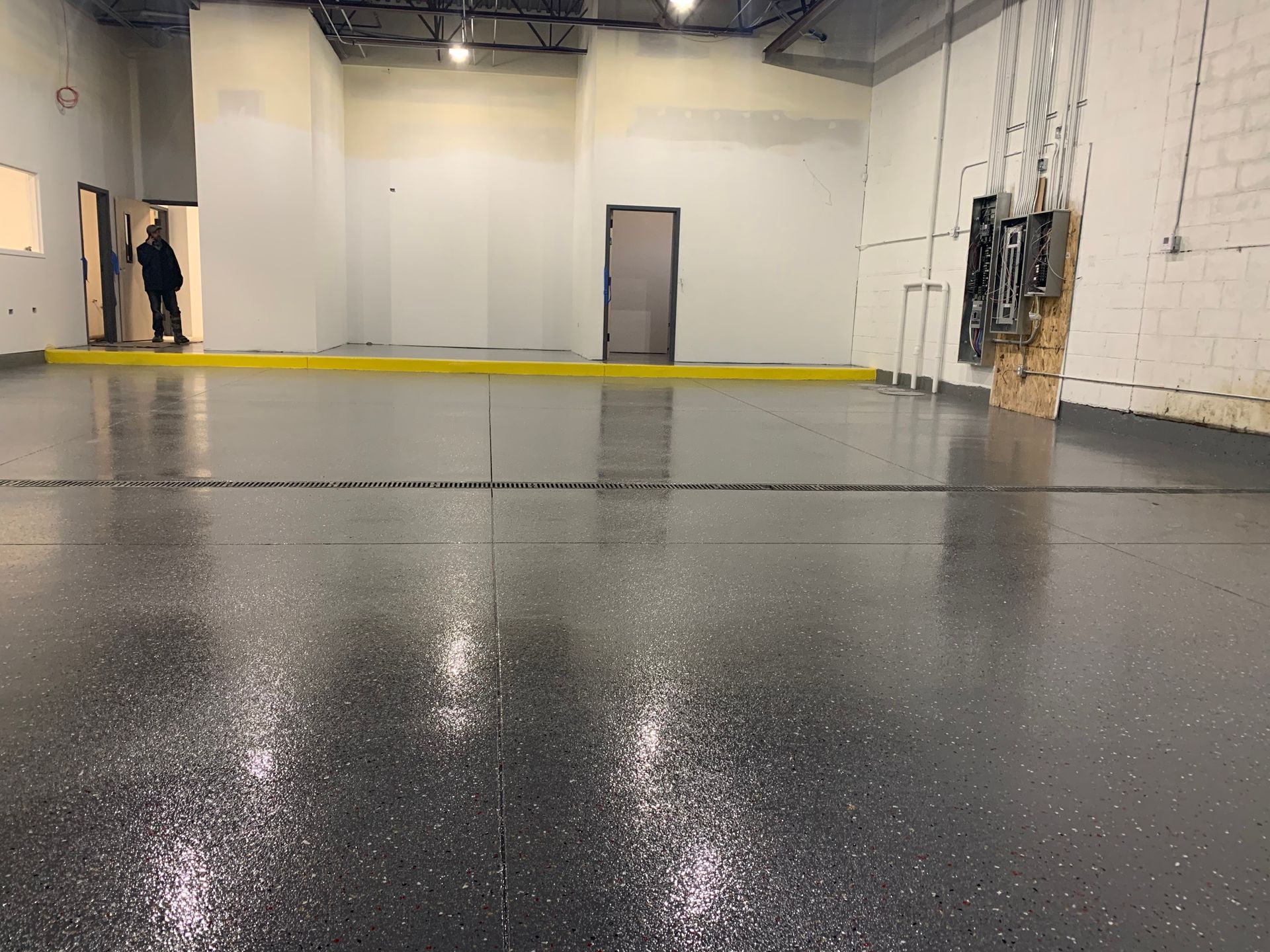 a man standing in an empty room with a gray floor