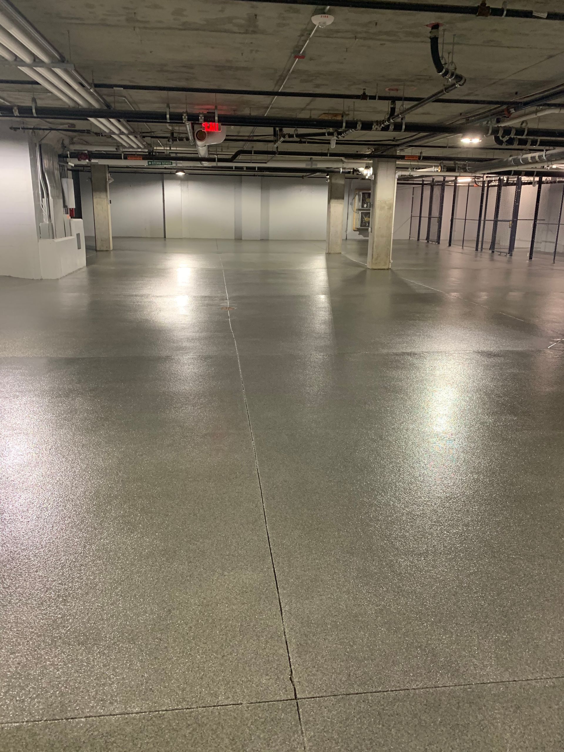 an empty underground parking garage with a shiny concrete floor