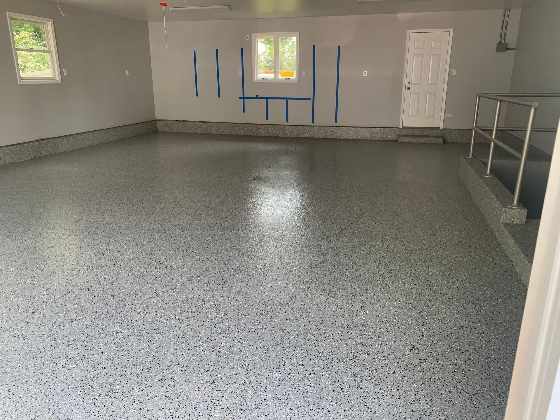 a large empty garage with a gray floor and white walls