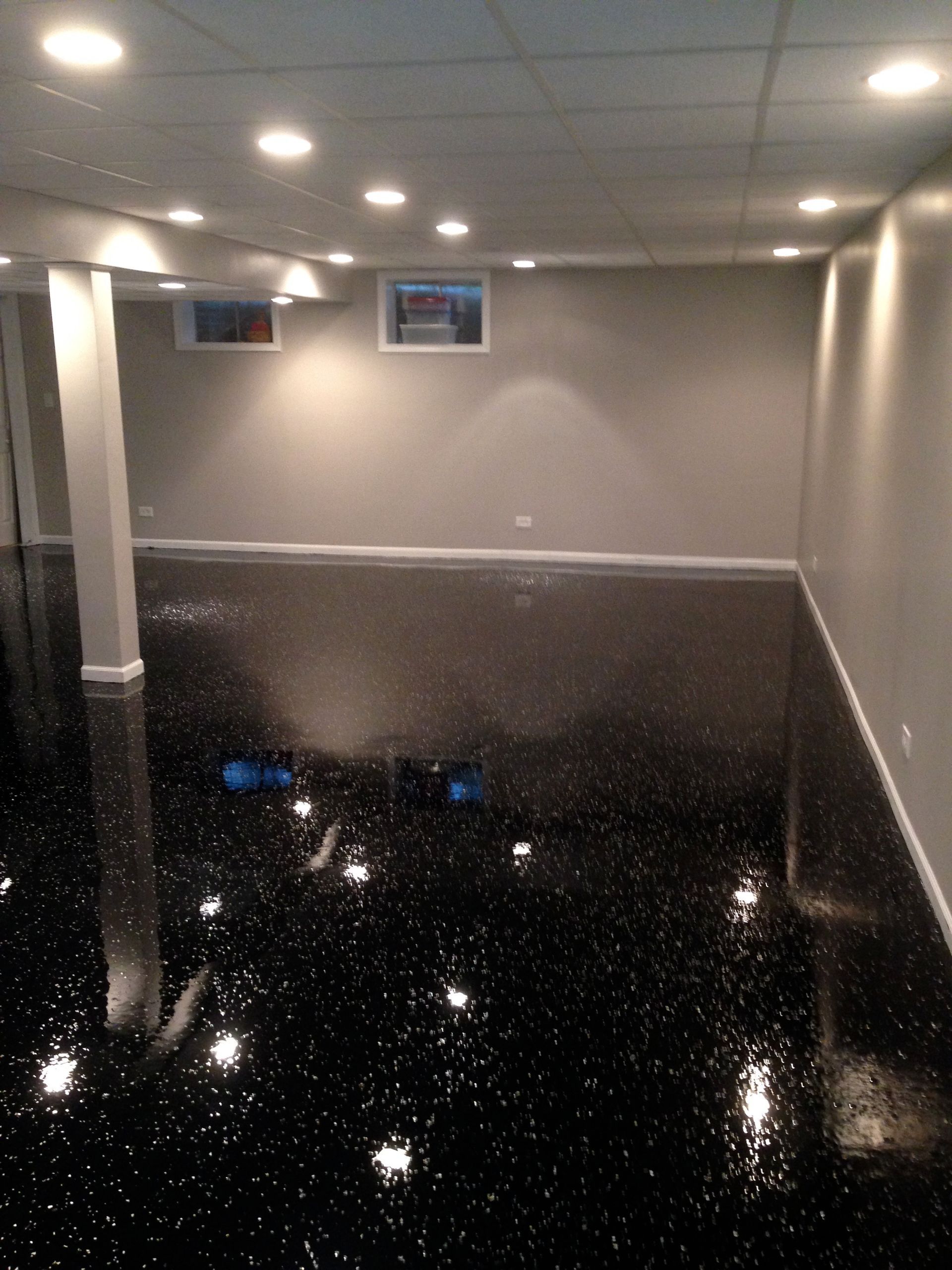 a basement with a black floor and white walls