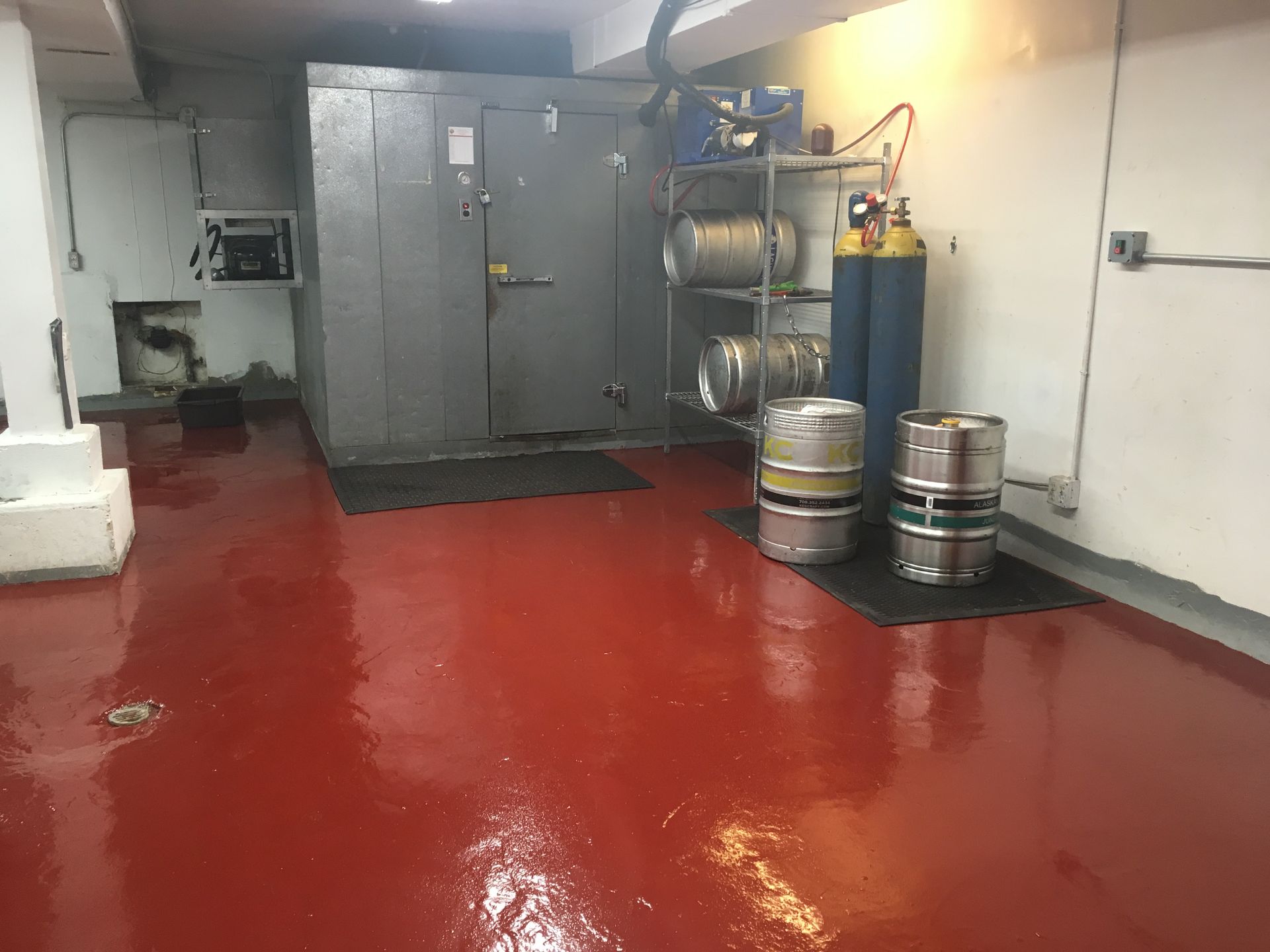 a room with red floors and barrels on the floor