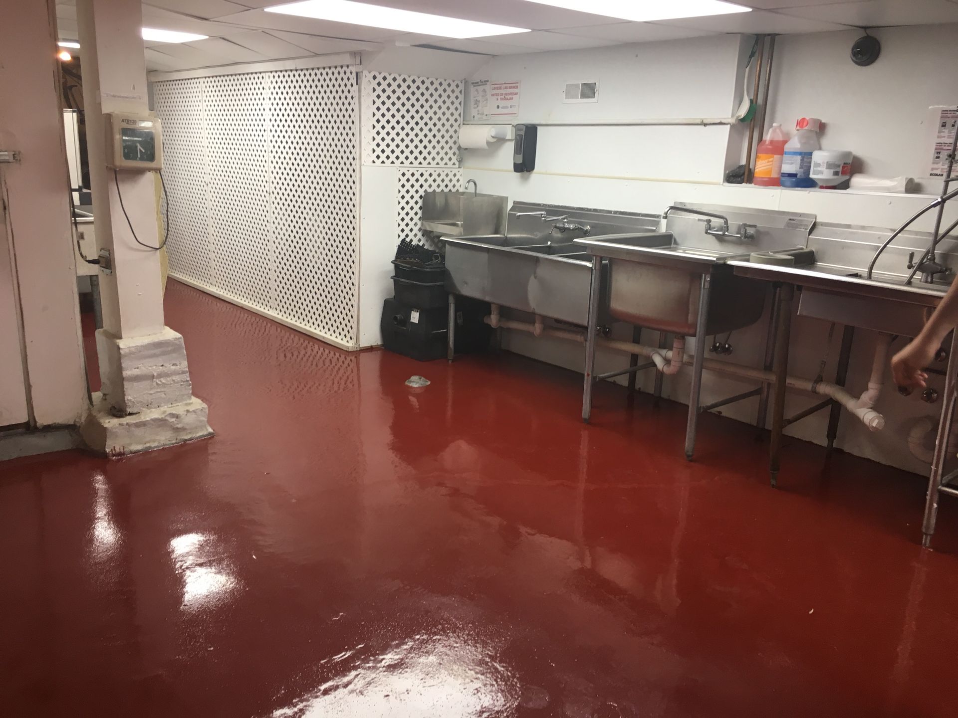 a kitchen with red floors and stainless steel sinks