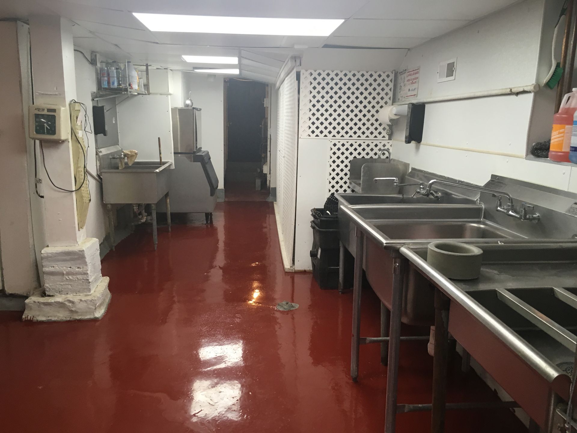 a kitchen with stainless steel sinks and a red floor