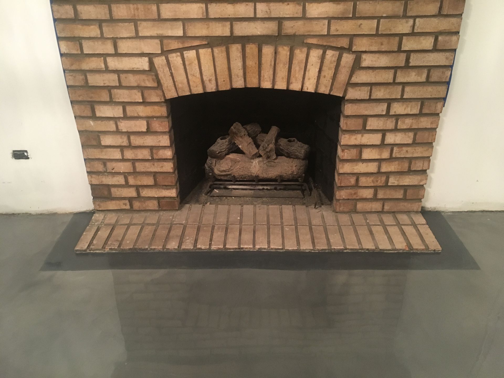 a brick fireplace with a wood burner in it