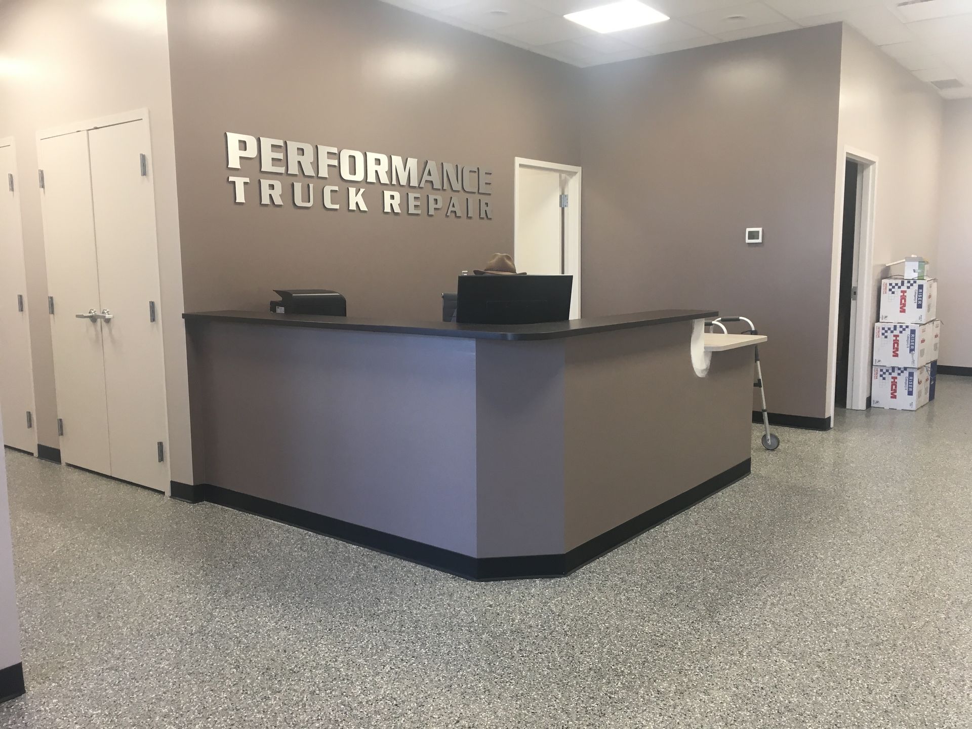a reception desk in a building that says performance truck repairs