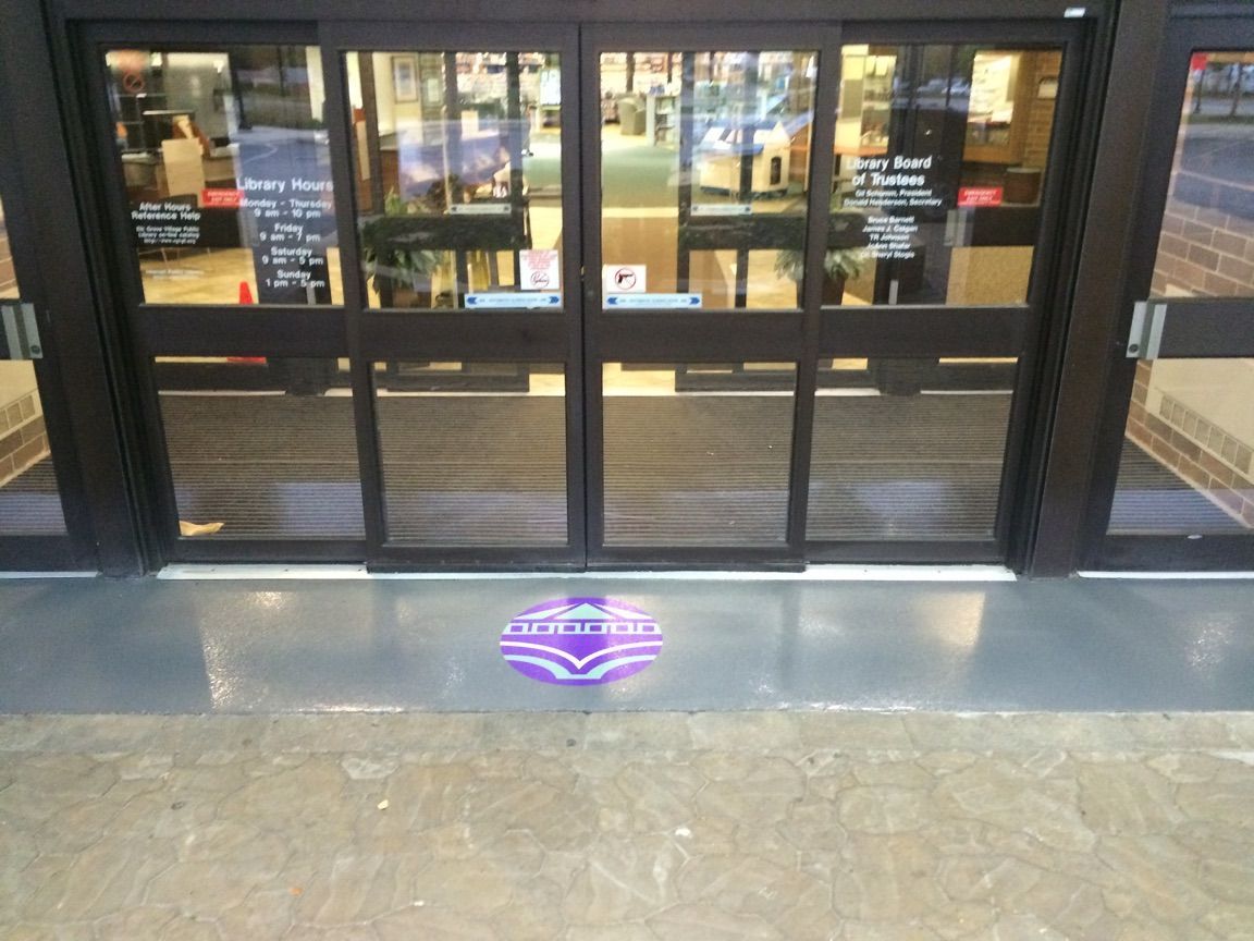 a sliding glass door with a purple logo on the floor
