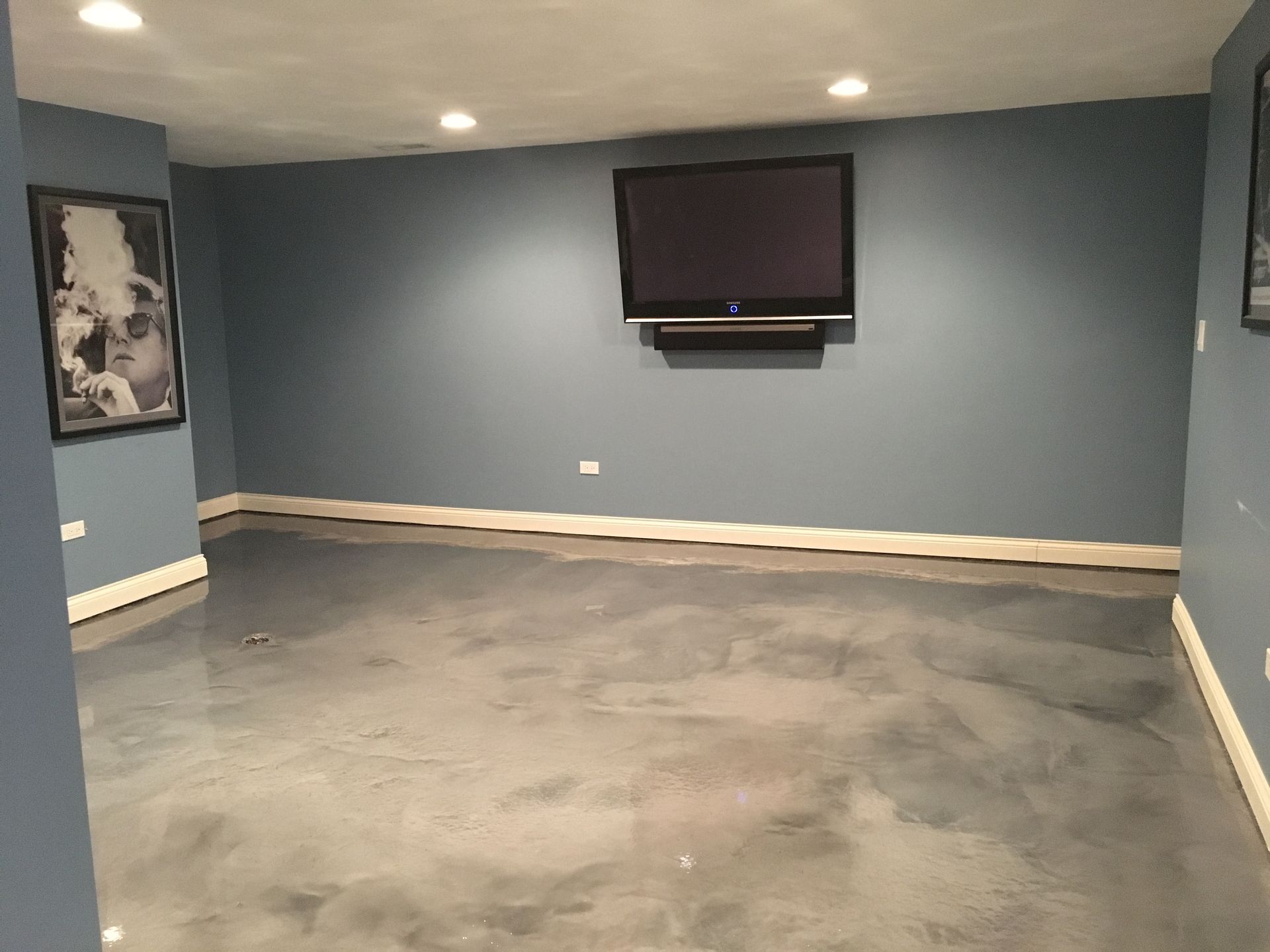 a basement with a flat screen tv on the wall