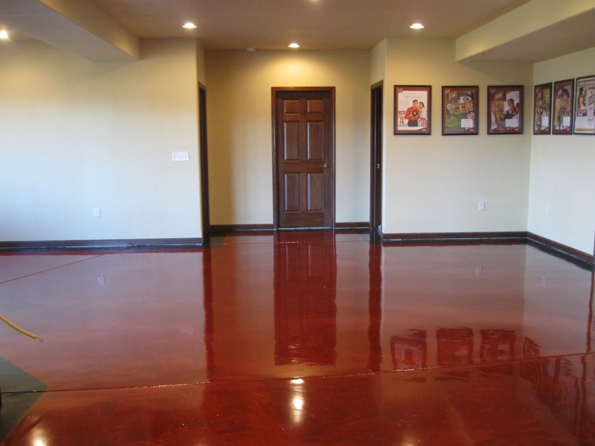 a room with a red floor and pictures on the wall