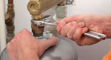 Plumber repairing a water heater tank