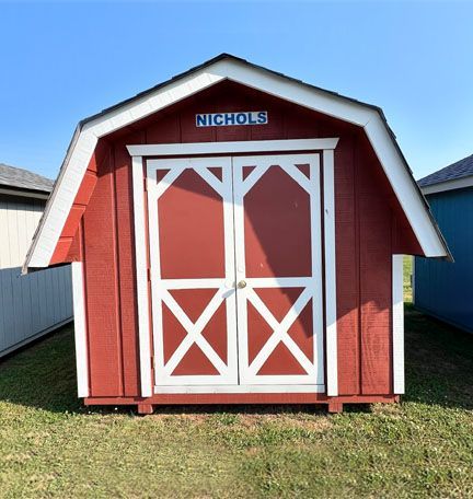 Red barn-style shed with white trim and double doors