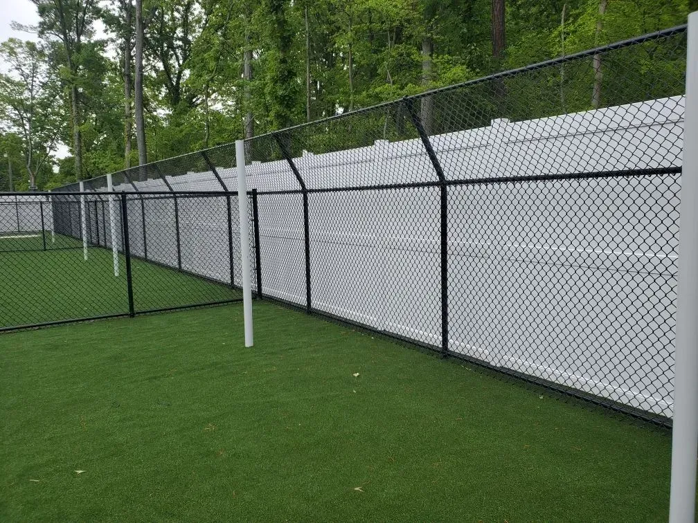 A white chain link fence surrounds a soccer field.