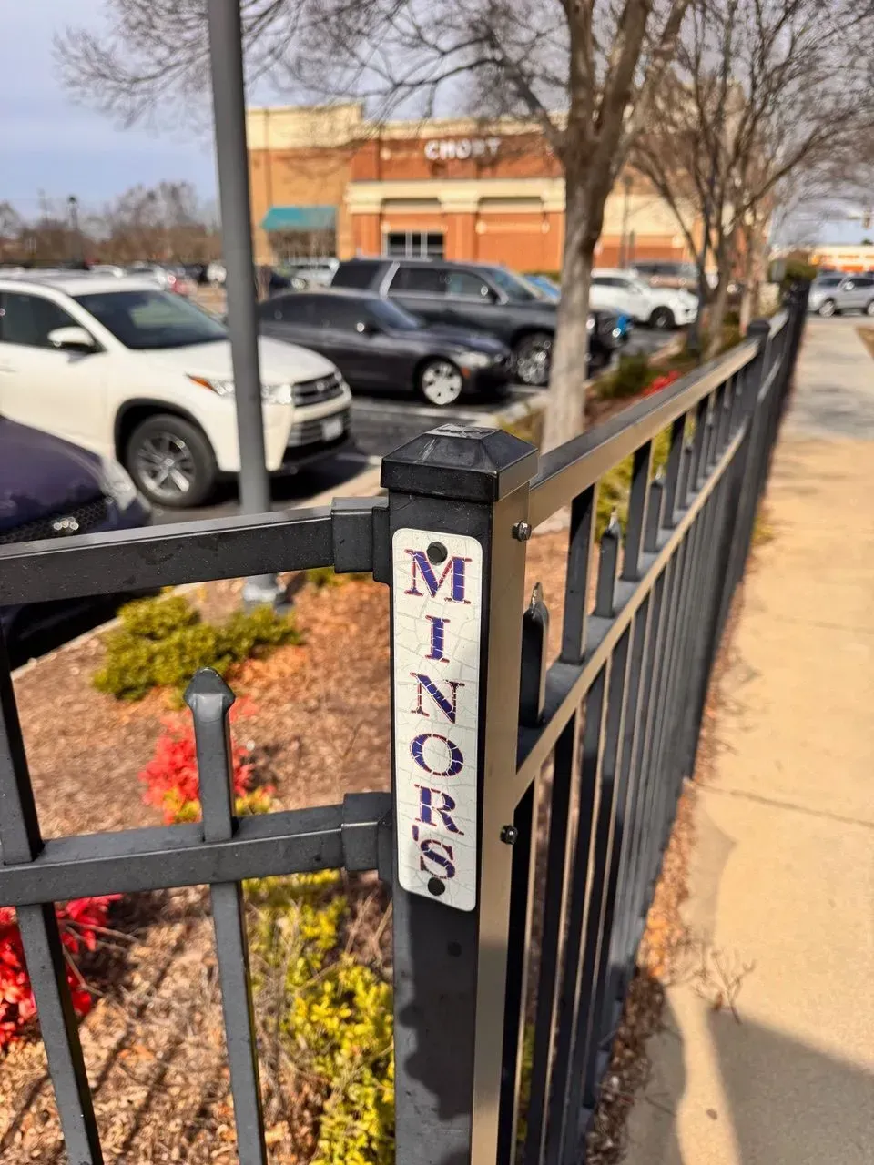 A sign on a fence that says minors on it.