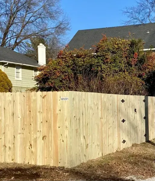 A wooden fence with a house in the background