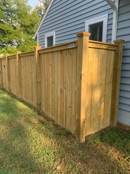 A wooden fence is sitting in front of a house.