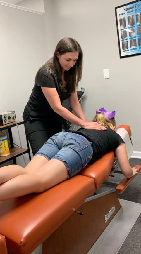 A woman is giving a child a massage on a table.