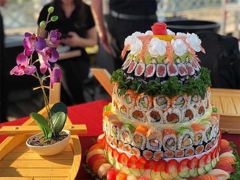 A cake made out of sushi is sitting on a table.