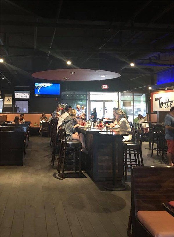 A group of people are sitting at tables in a restaurant.