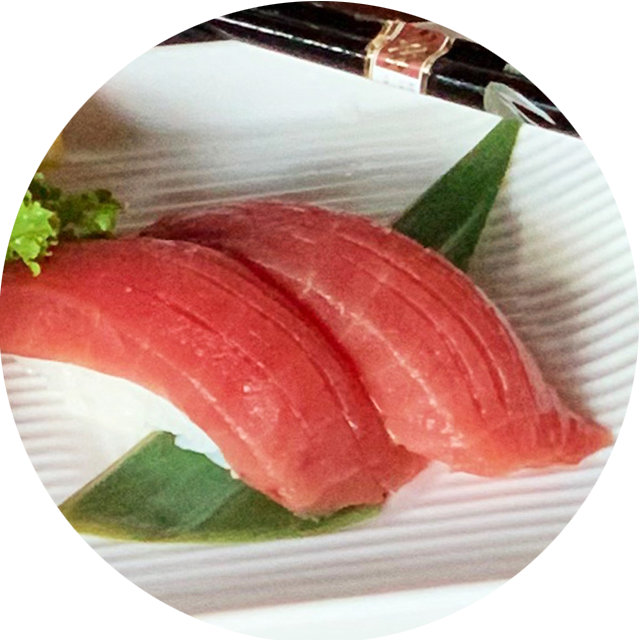 A close up of sushi on a plate with chopsticks