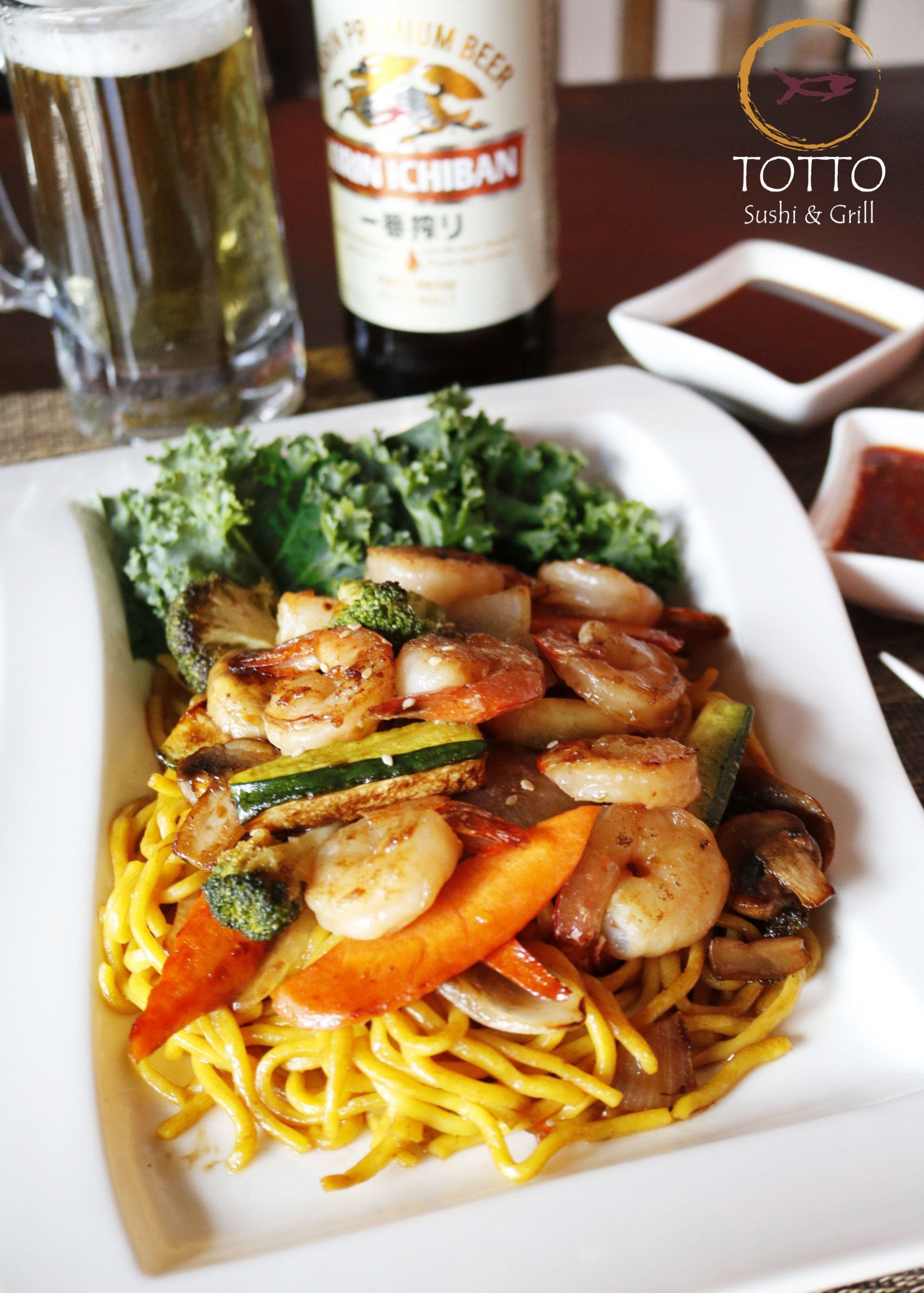 A plate of food with a bottle of kirin beer in the background