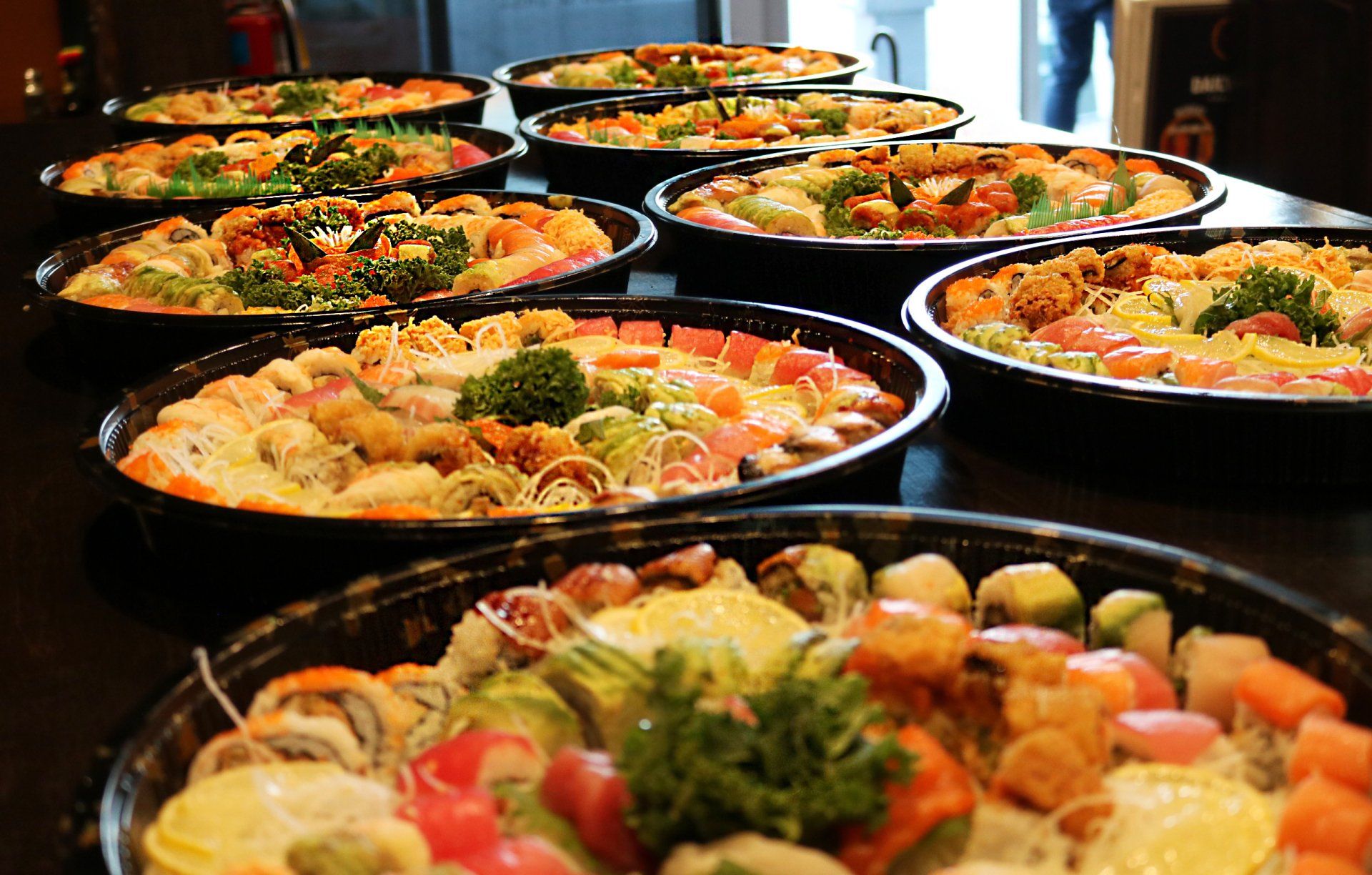 A row of plates of food are lined up on a table.