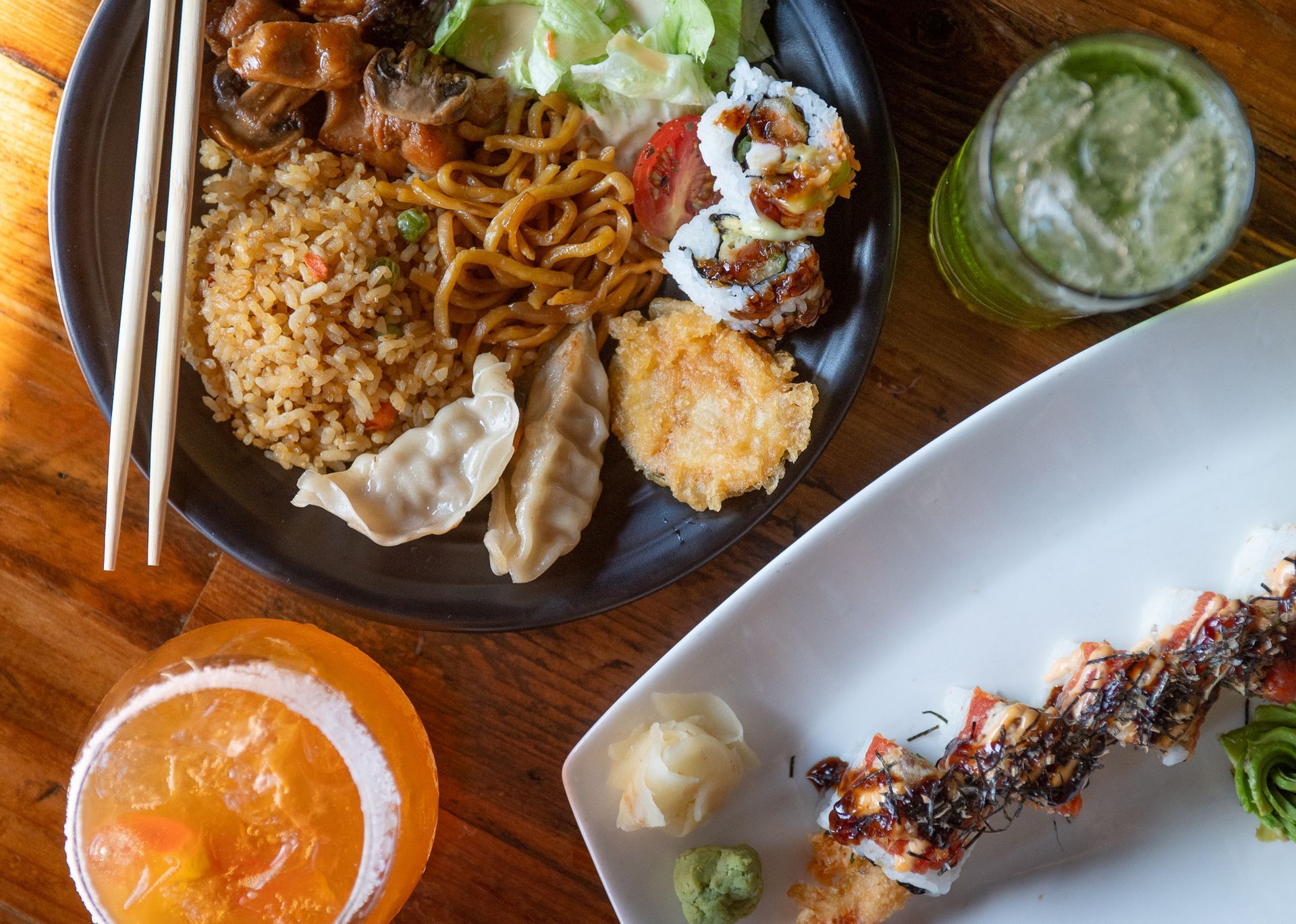 A plate of food with chopsticks and a drink on a table.