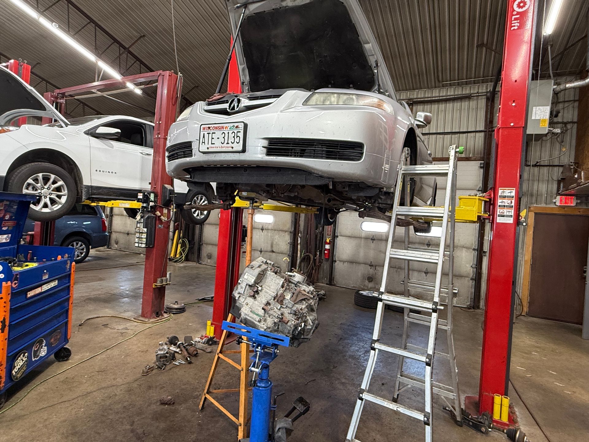 A car is sitting on a lift in a garage.