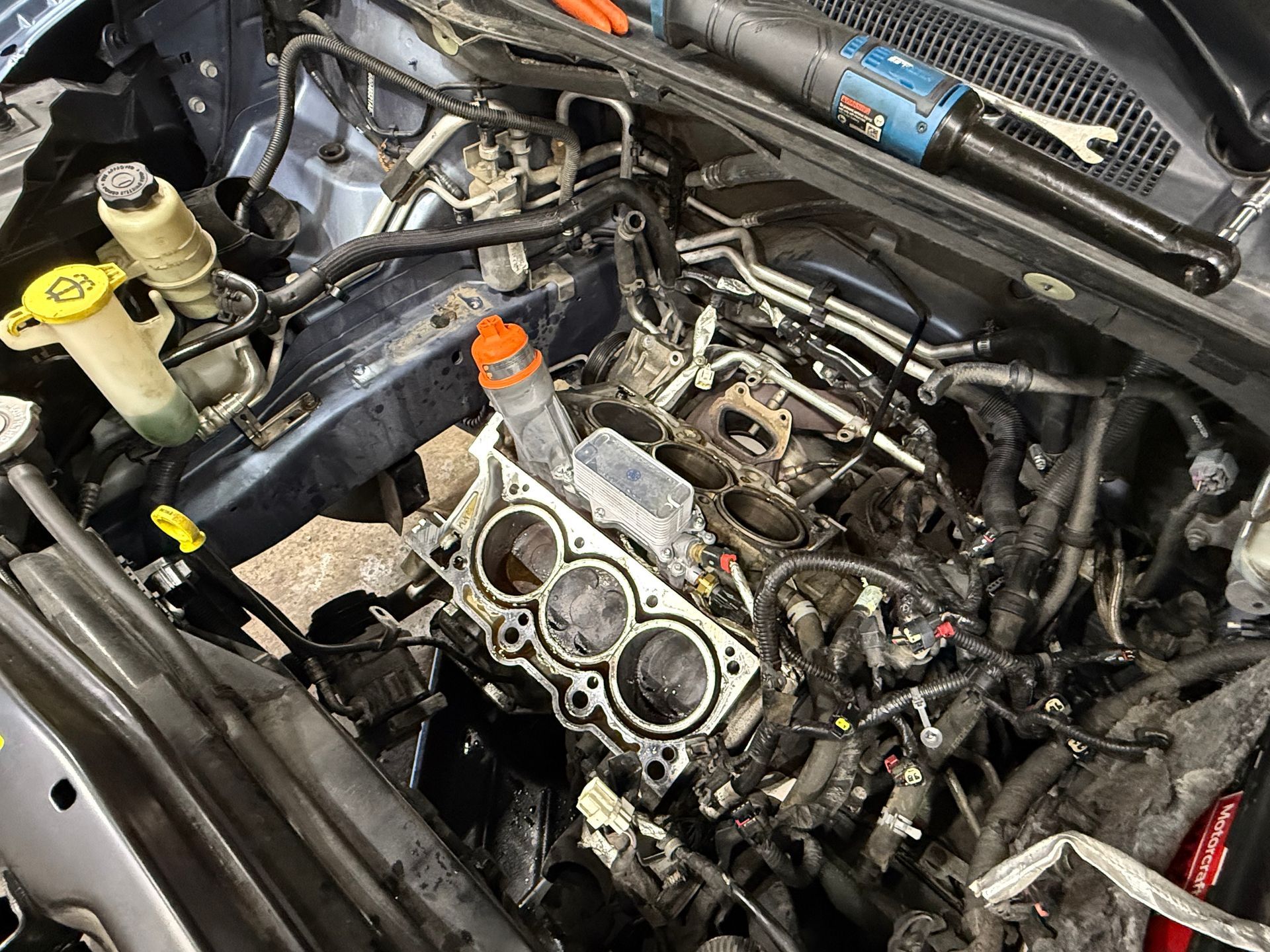 A close up of a car engine with the hood open.