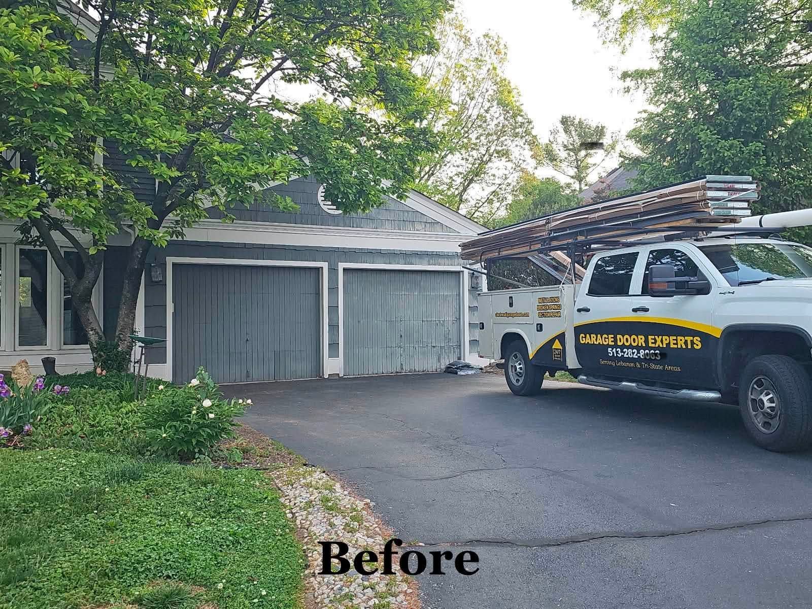 Before: driveway with a garage, trees, and a work truck parked on the right