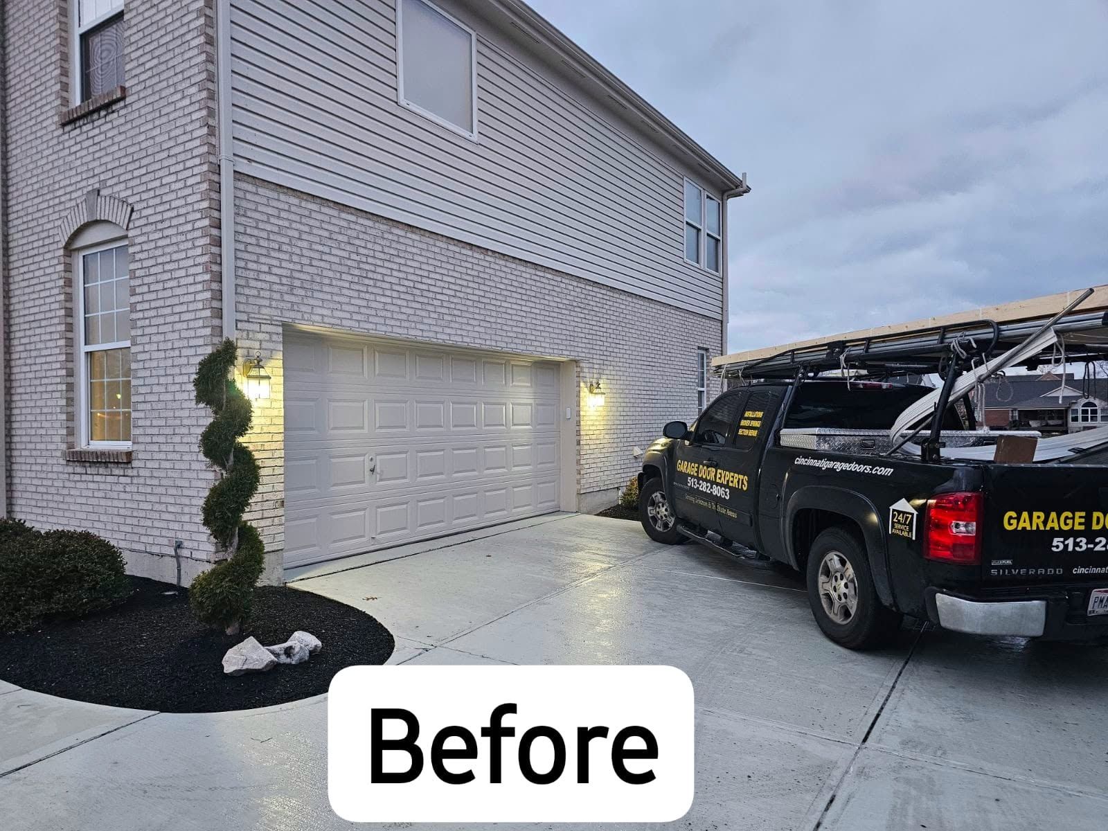 Garage and black work truck in a driveway beside a white house at dusk, labeled “Before”