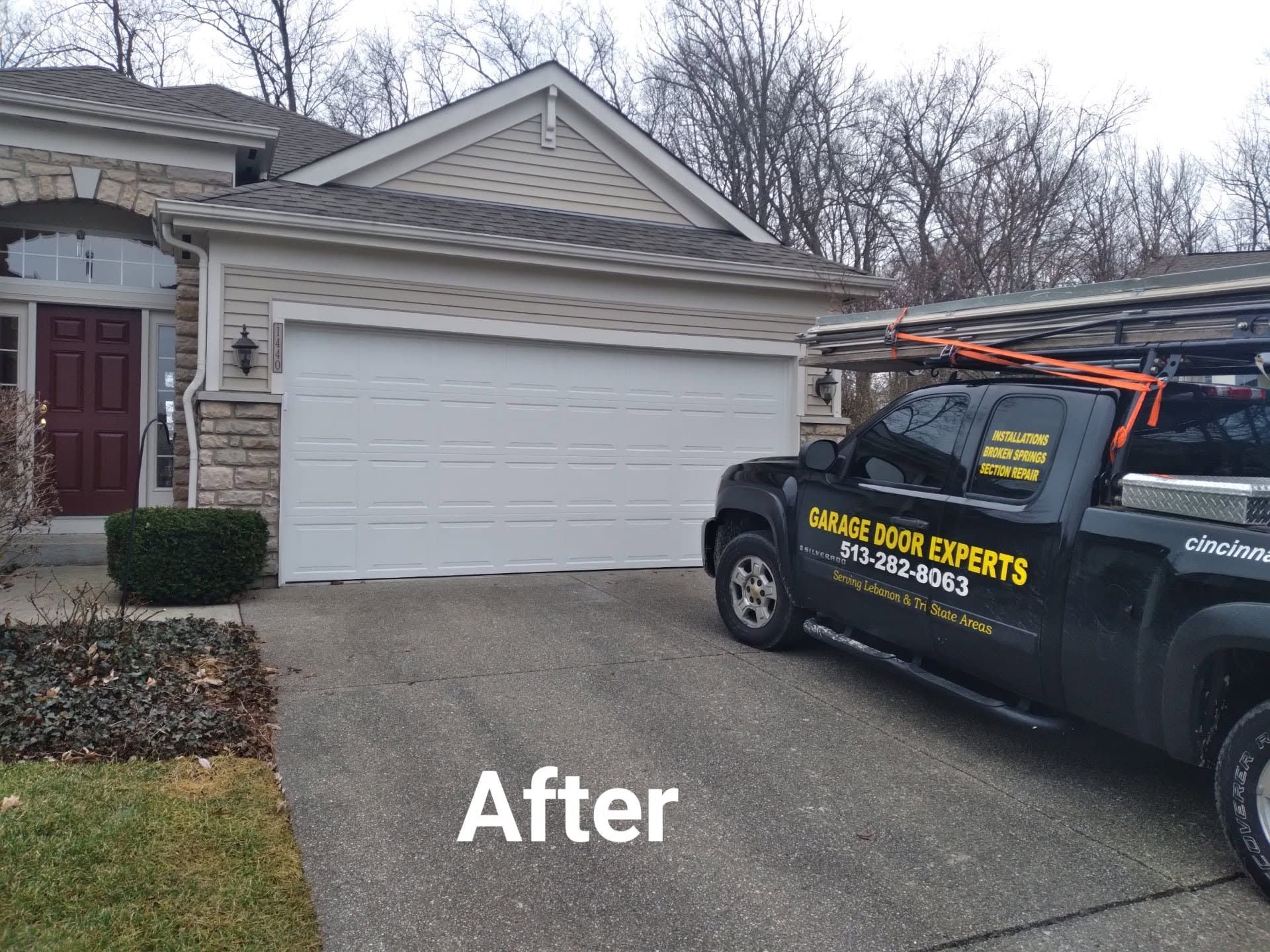 Driveway and garage after resurfacing, with a black service truck parked beside the house.