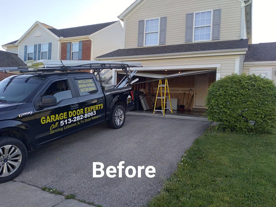 Before photo of a driveway and open garage with a work truck and ladder in front of a house