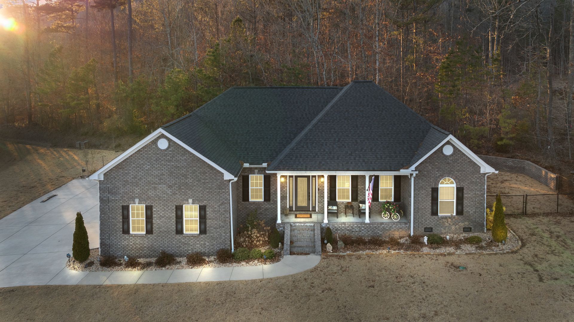 An aerial view of a brick house with a black roof