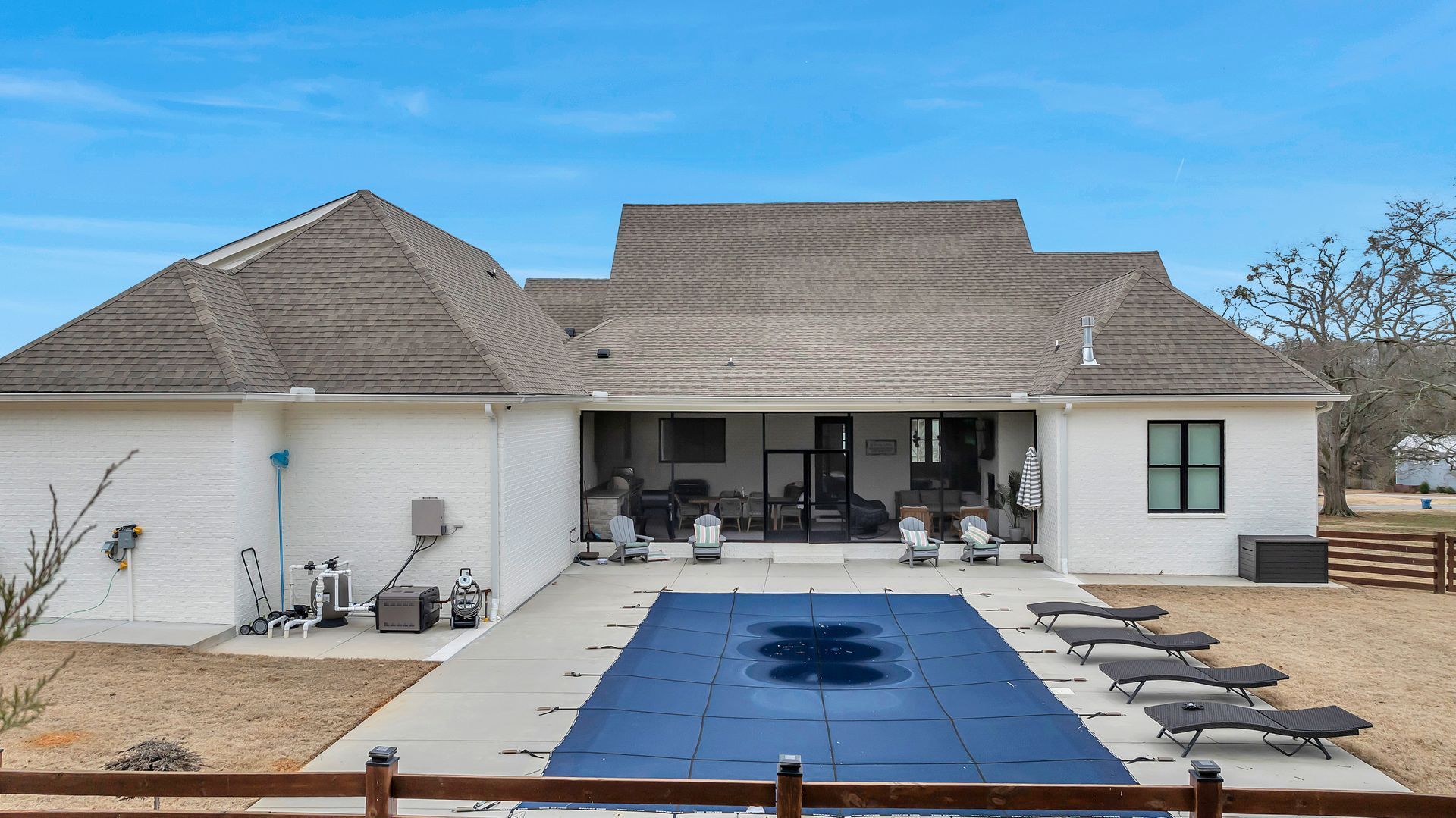 A large white house with a large swimming pool in front of it.