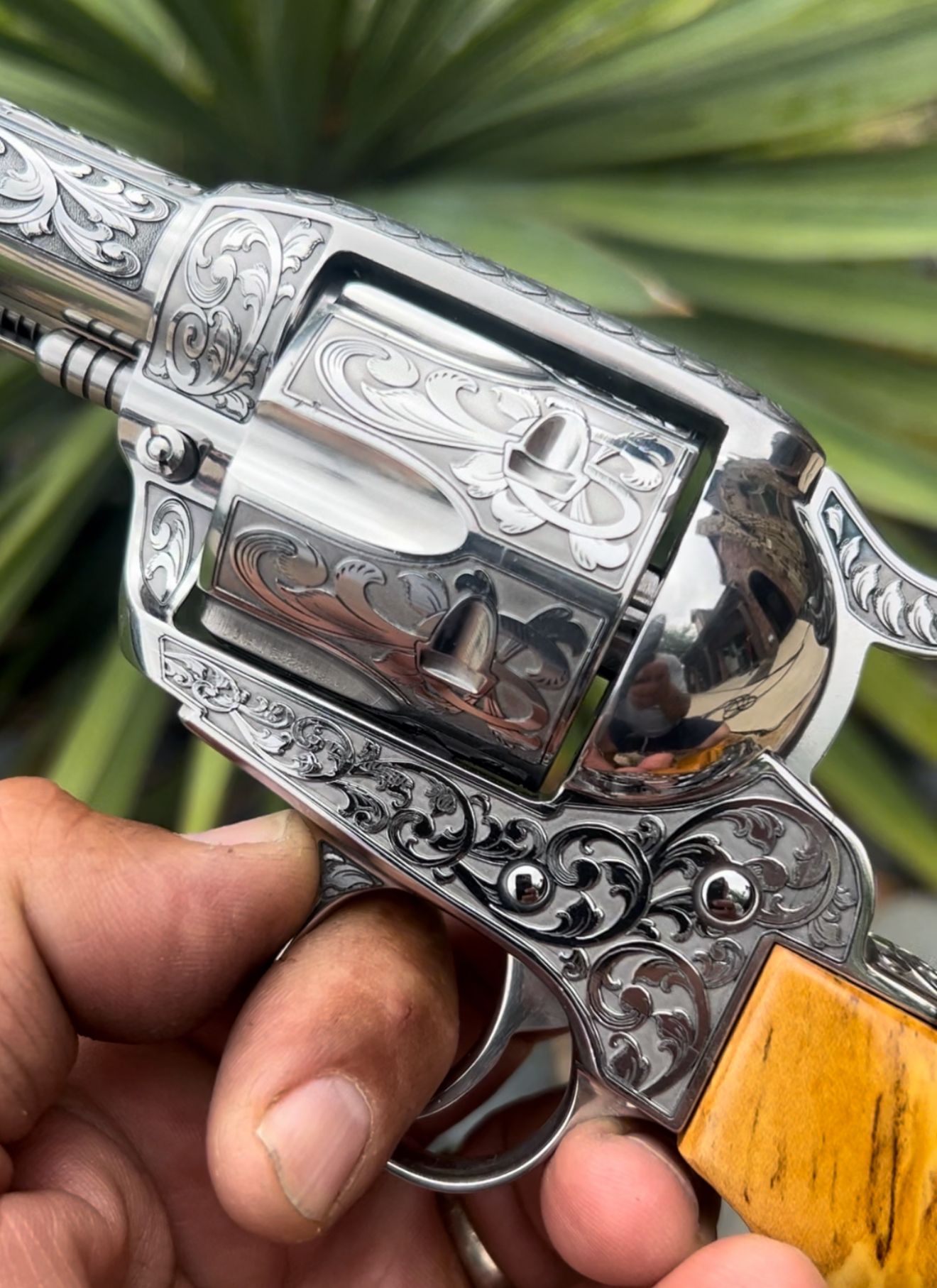 A person is holding a silver revolver with a wooden handle.