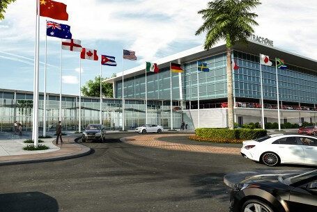 Cars are parked in front of a building with flags in front of it