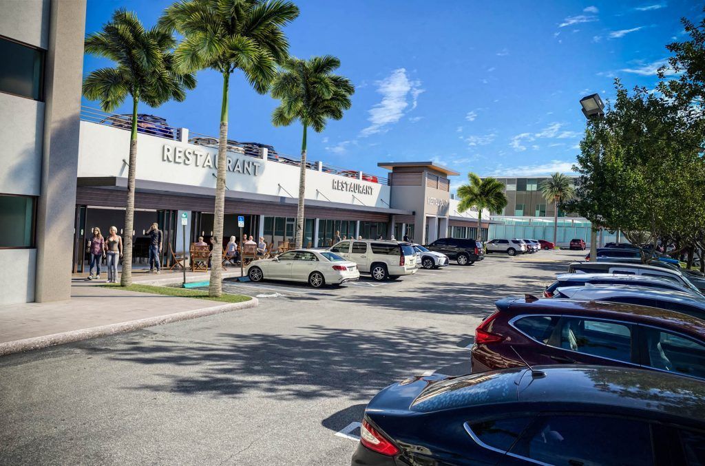 Exterior of a shopping center with a restaurant, parking lot, palm trees, and parked cars under a blue sky.