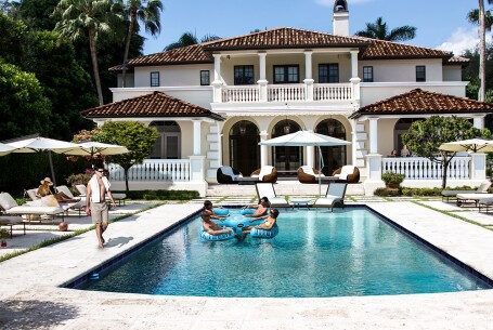 A large white house with a large swimming pool in front of it