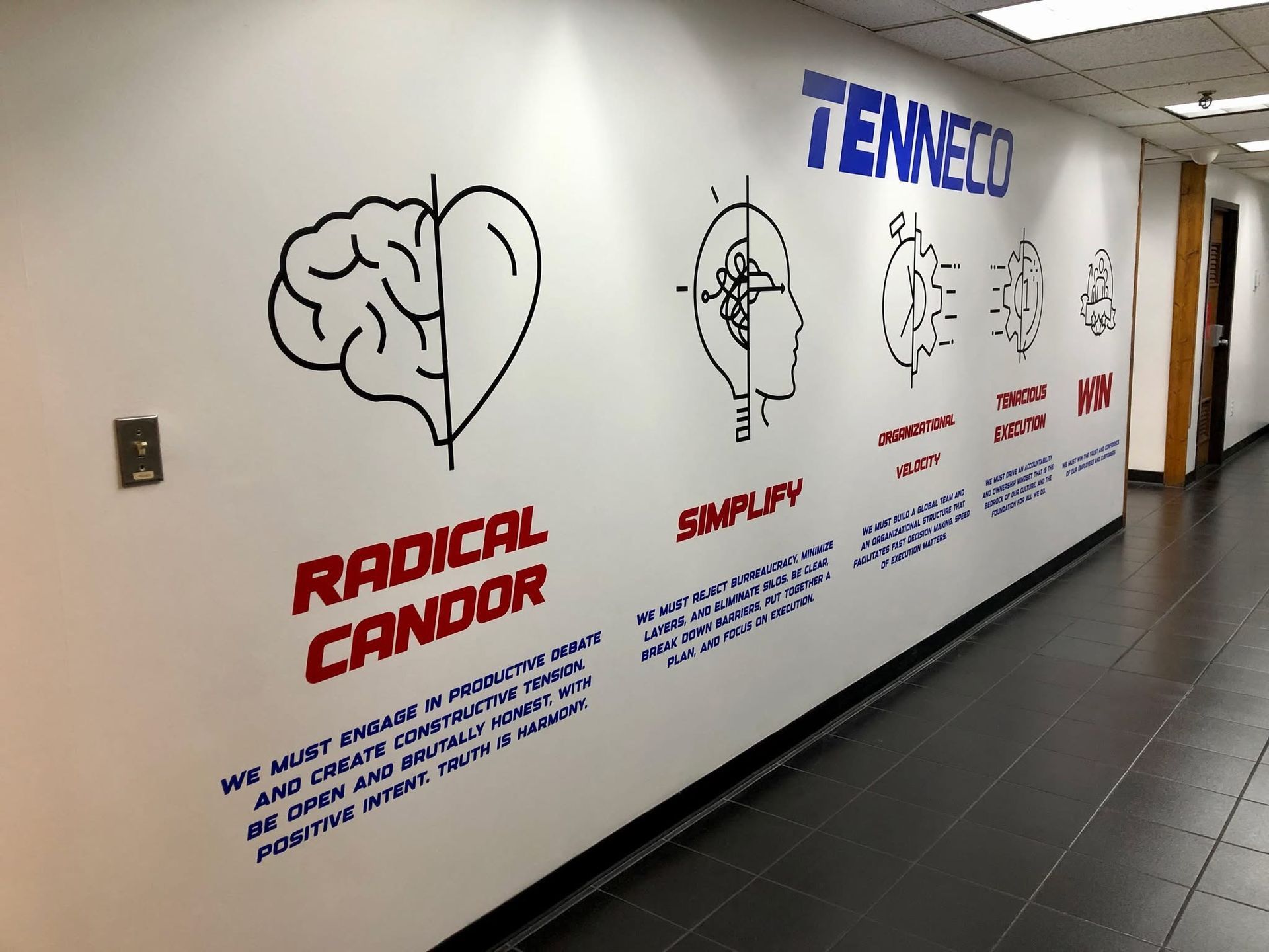A hallway with a wall that says tenneco radical candor