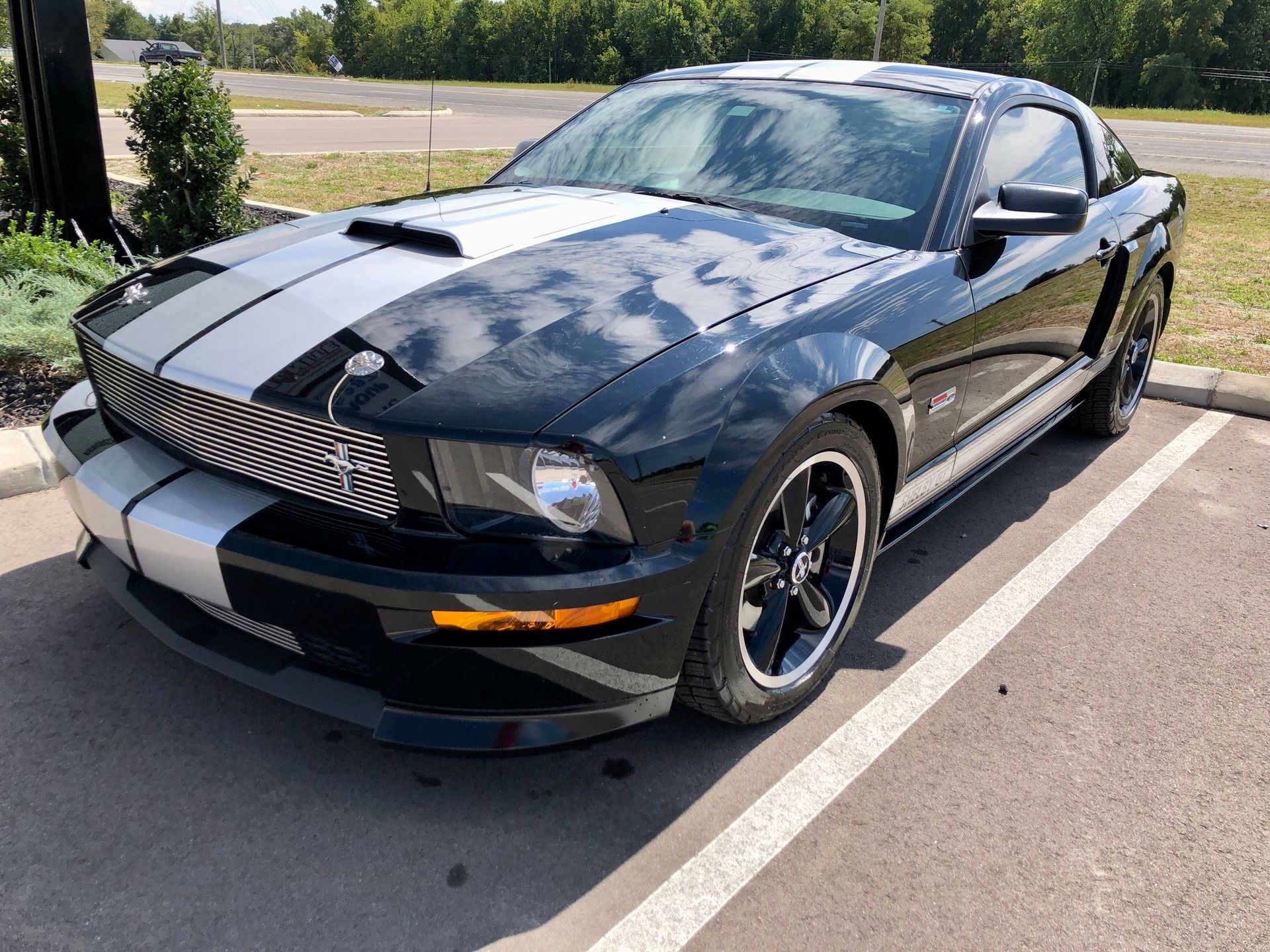 A black and white mustang is parked in a parking lot.