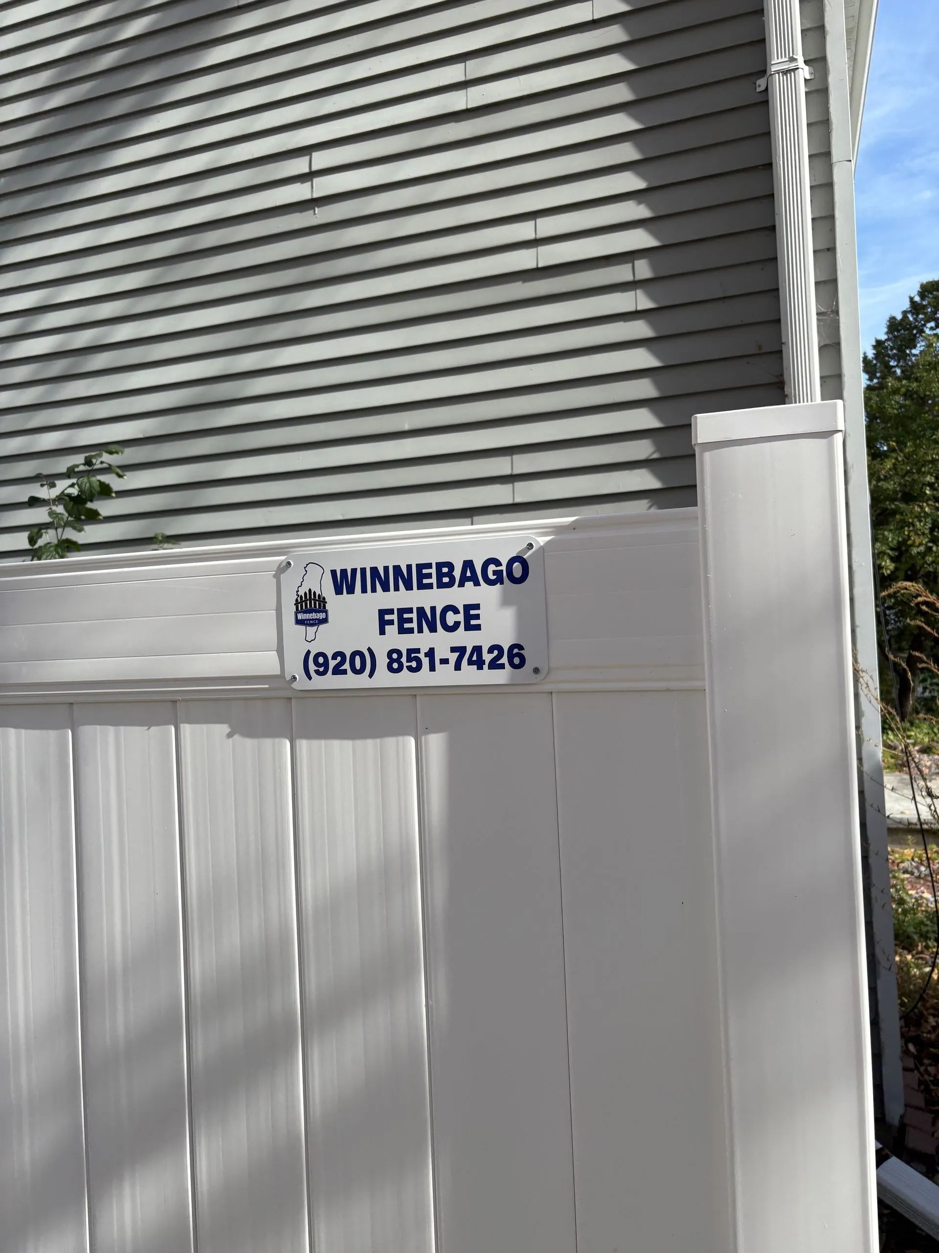 White vinyl fence with a sign.
