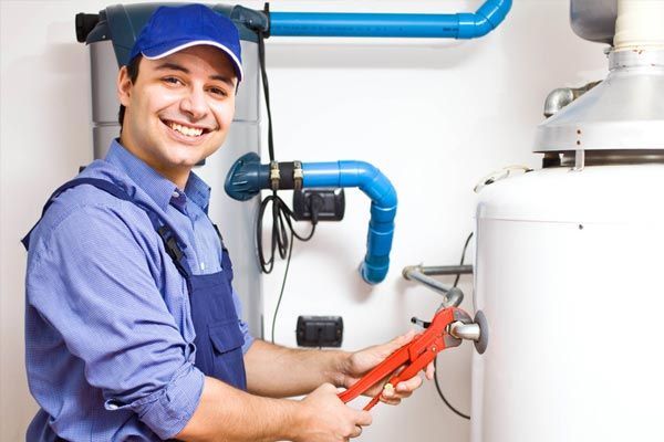 a plumber is smiling while fixing a water heater