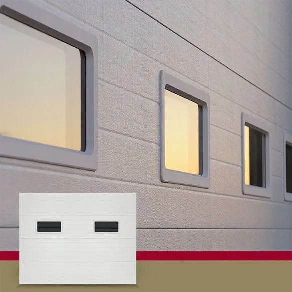 White industrial building wall with small windows and a red stripe near the bottom
