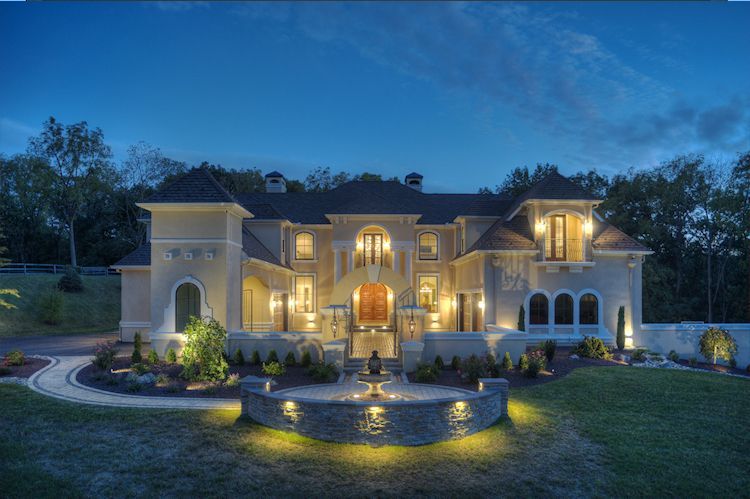 A large house with a lot of windows is lit up at night.