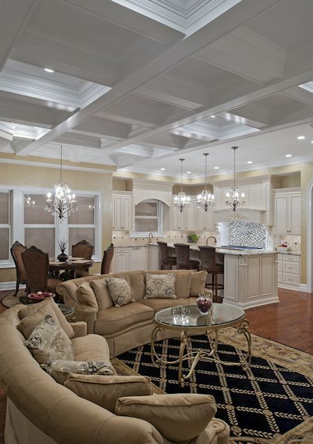 A living room with a coffered ceiling and a couch and chairs