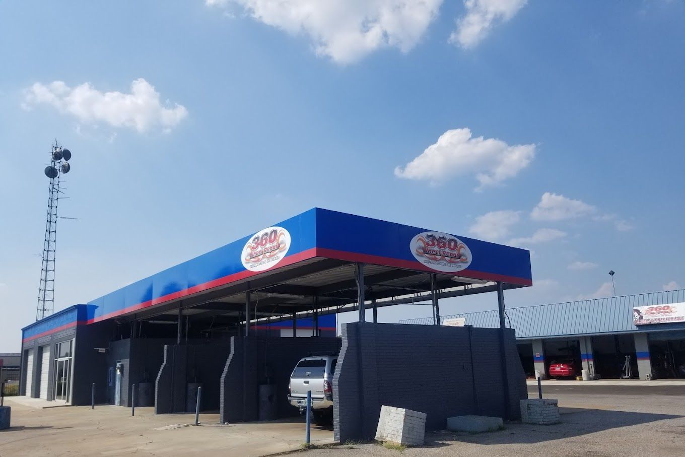Car wash with blue and red canopy; clear sky.