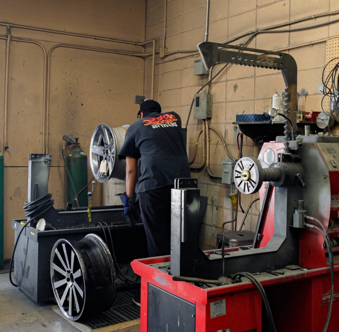 Mechanic balancing a car wheel in a garage.