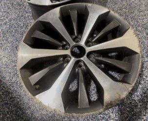 Silver and black alloy wheel with 10 spokes - before